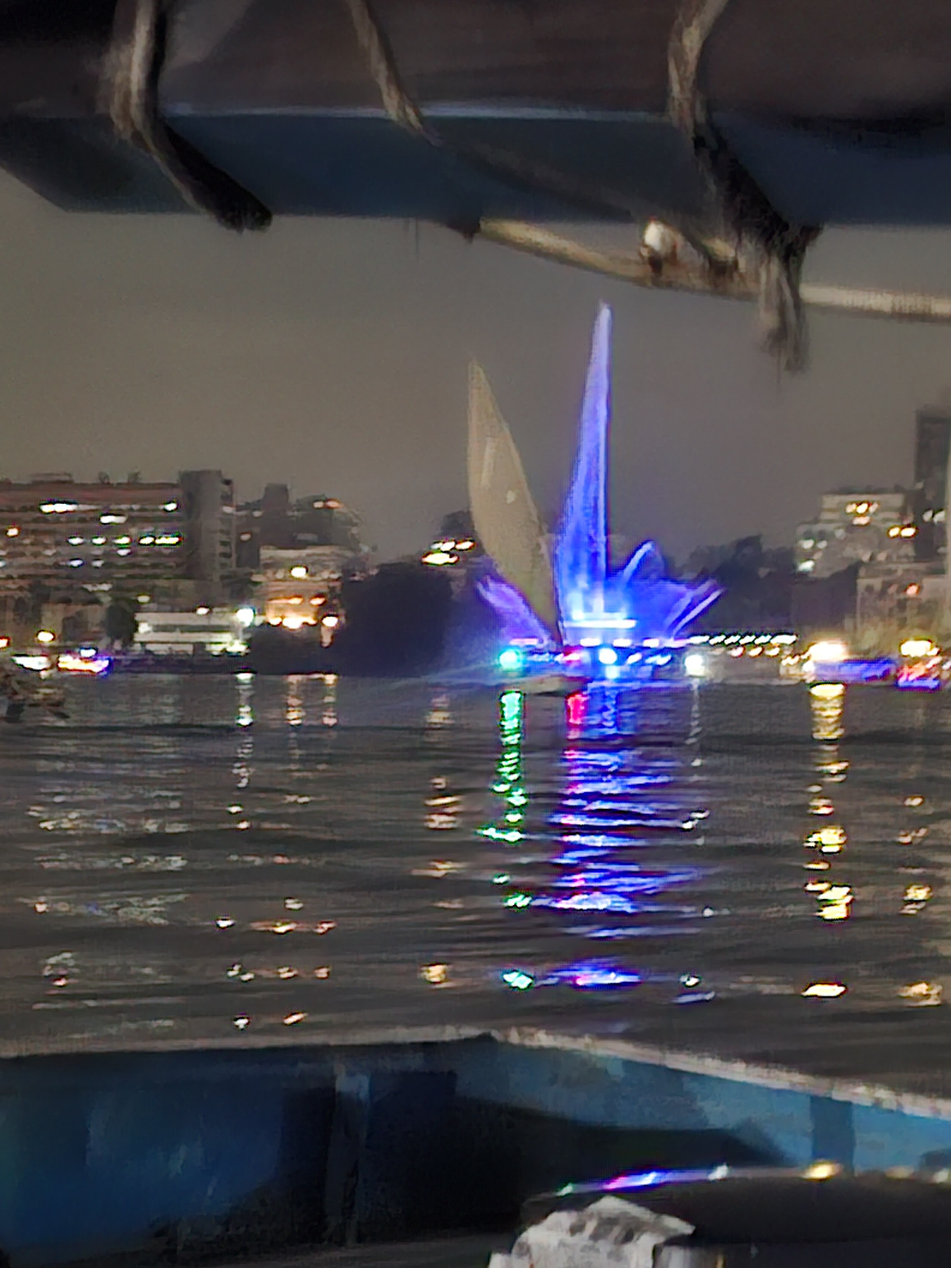 Night view of the River Nile with illuminated boats and a fountain display in Cairo.